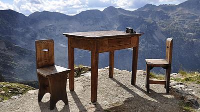 Tisch mit Stühlen in den Bergen.